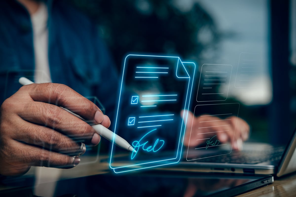 Business professional signing a digital document electronically on a laptop and tablet during remote online notarization